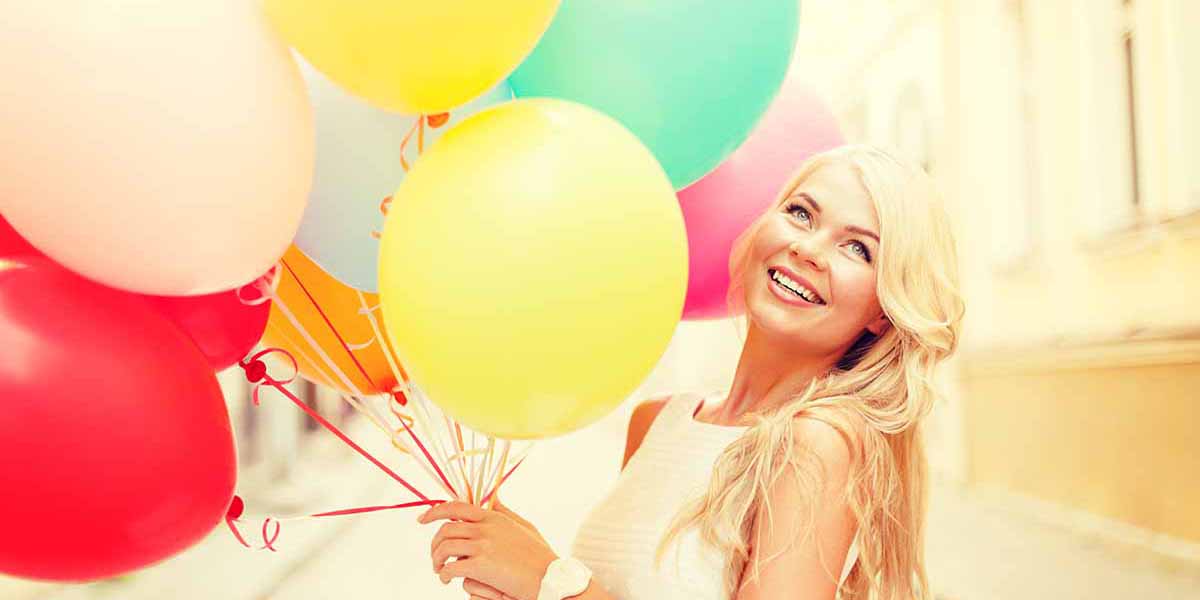 smiling woman with colorful balloons